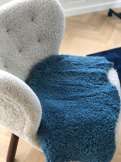Blaues Kurzhaar Lammfell auf einem Stuhl